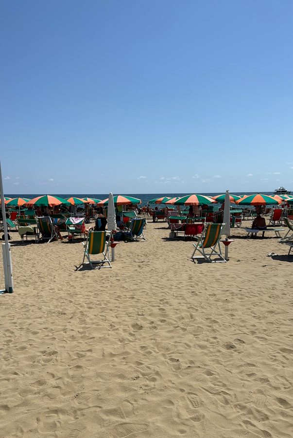 Le file di ombrelloni arancioni e verdi verso il mare